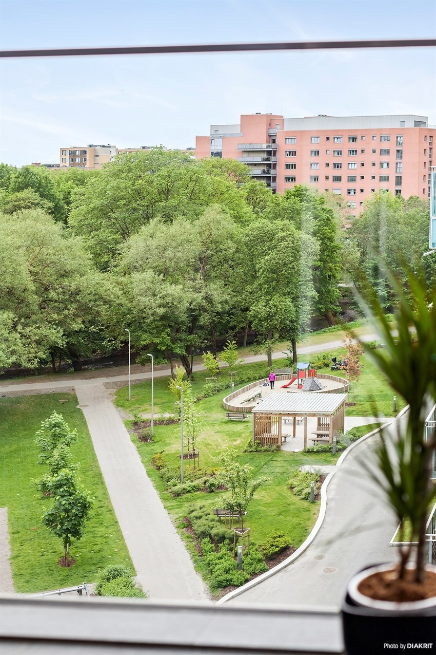 Felles tomt for sameiet beplantet med trær, busker, blomster og plen. Asfalterte internveier, utebelysning, fotballbane og sittegrupper. (arkivbilde) Galleribilde