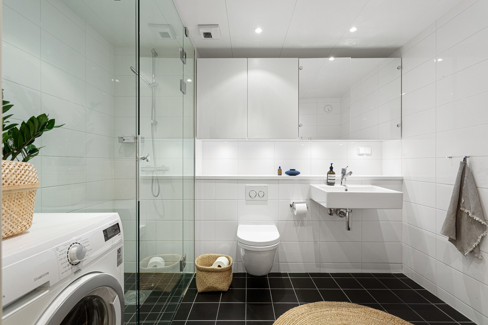 Leiligheten har et lyst og moderne flislagt baderom fra byggeår 2014. Baderommet har mørke fliser på gulv med gulvvarme, lyse fliser på veggene og downlights i himlingen. Galleribilde