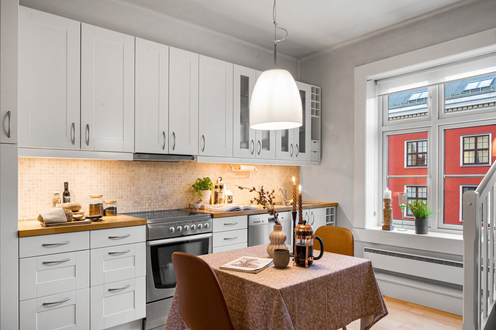 Kjøkkeninnredning med hvite profilerte fronter montert i 2004. Galleribilde