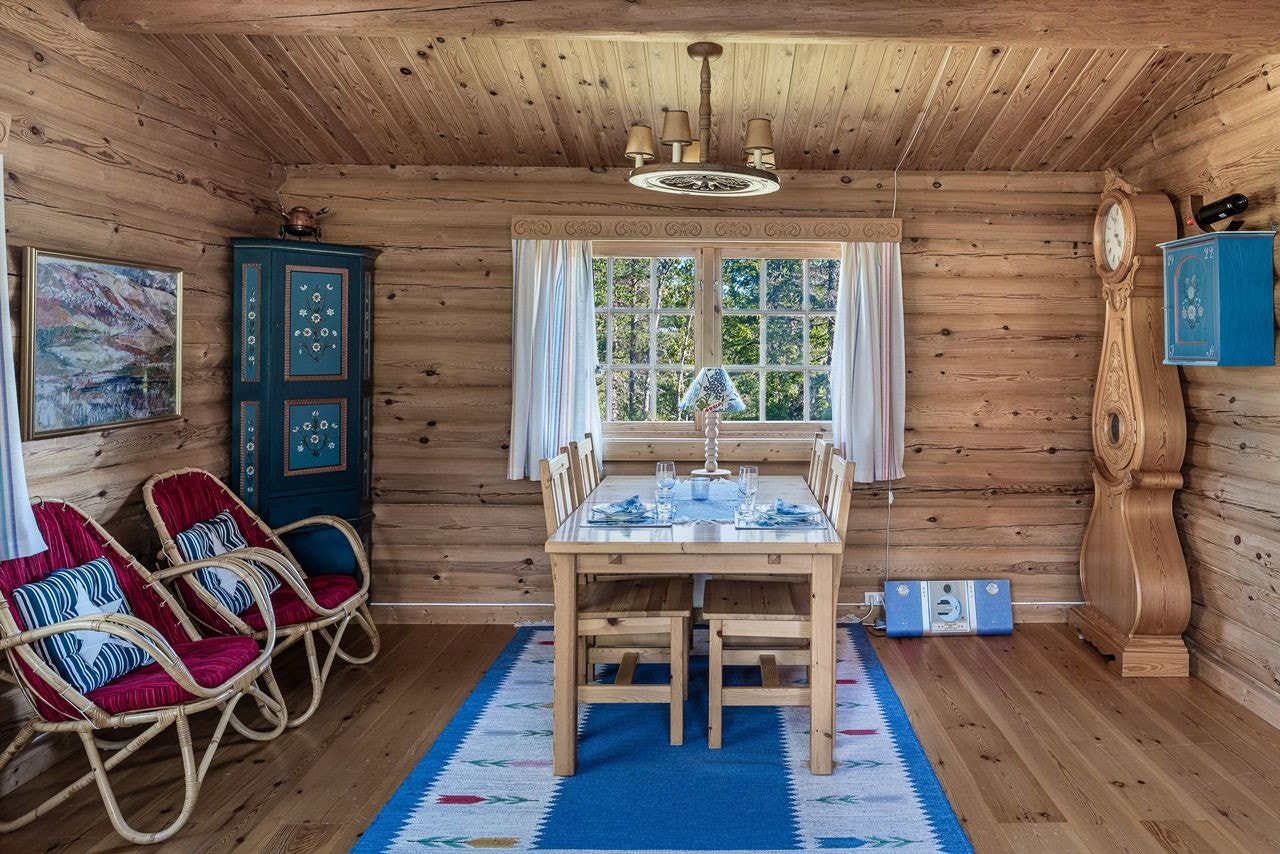 Det er god plass til et spisebord for hele familien. Ubehandlede tømmervegger, tretak og et fint tregulv i stua Galleribilde