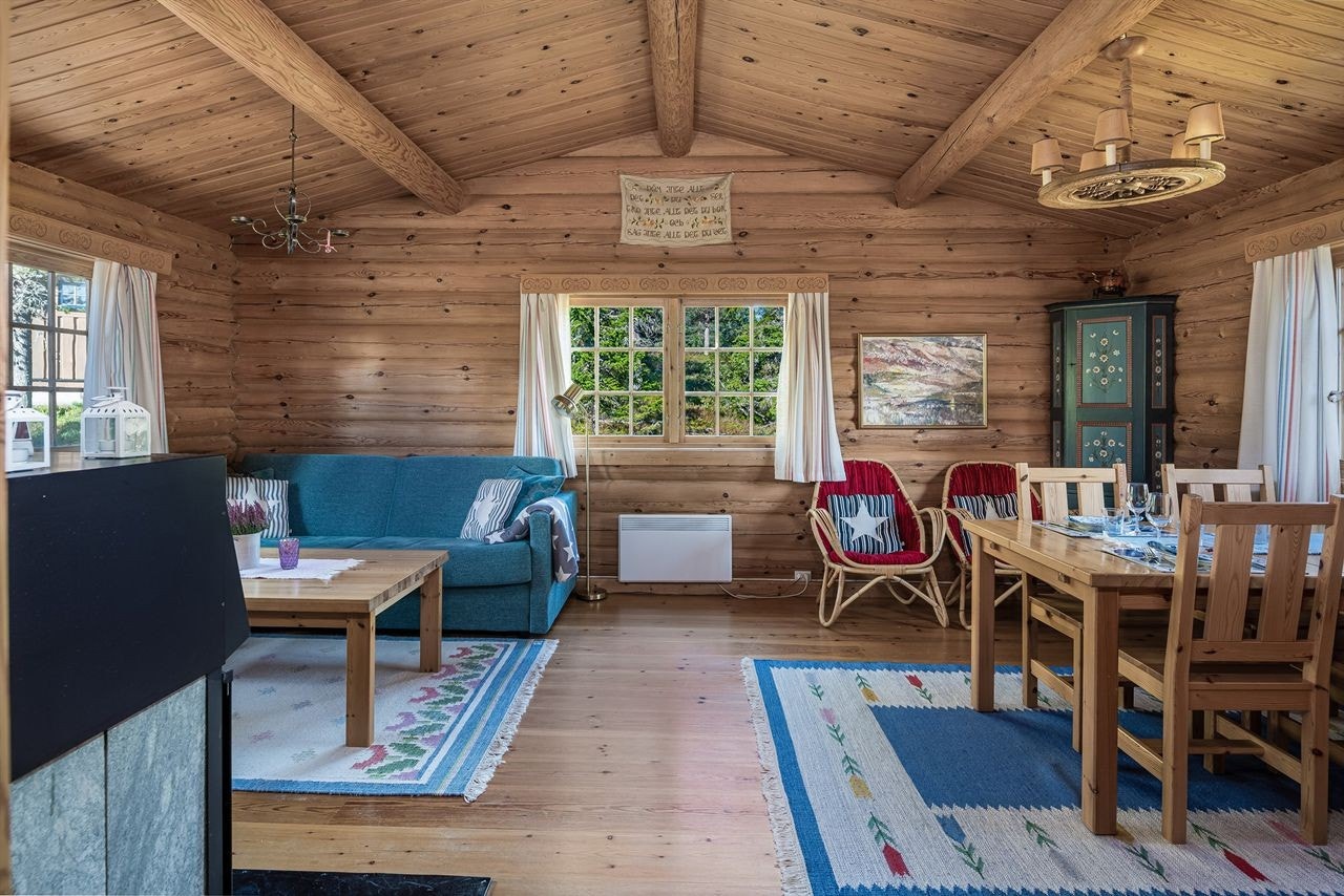 Koselig stue med sofakrok og spiseplass. Synlige takåser og god takhøyde gjør rommet luftig. Vinduer på tre vegger gir gjennomgående lys og fin utsikt Galleribilde