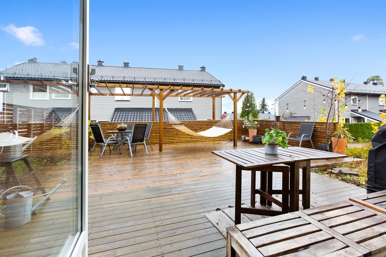 Utgang fra stue til nordvestvendt og solfylt terrasseplatting på hele 95 m², som strekker seg videre ut til en hage med trapp ned til gangvei. Galleribilde