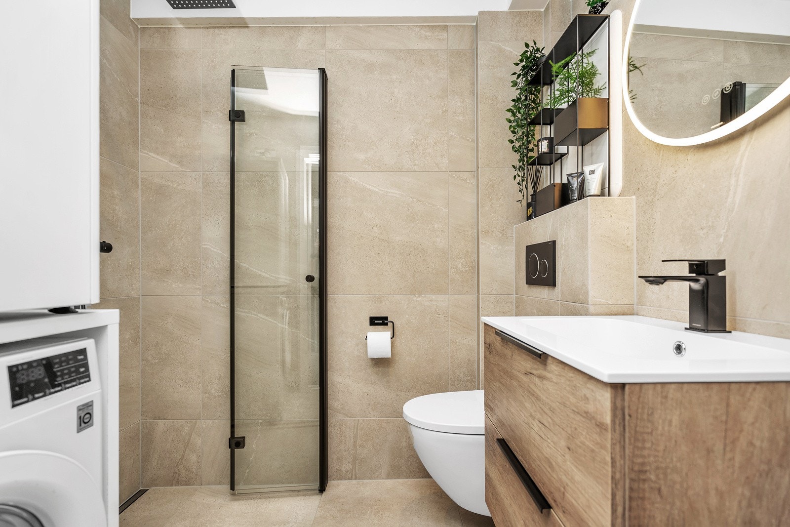 Lekkert flislagt bad med vegghengt toalett, servant med innredning og dusjnisje Galleribilde