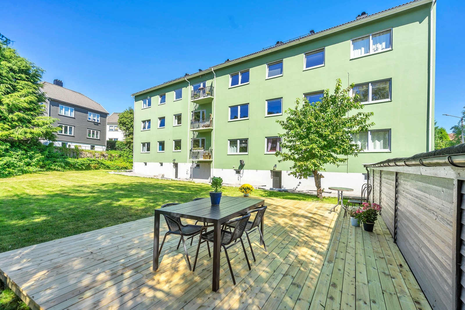 I hagen er det stor gressplen og platting Galleribilde