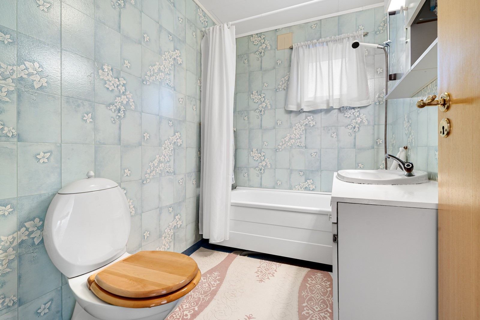 Badet er innredet med badekar, innredning med nedfelt servant og toalett.