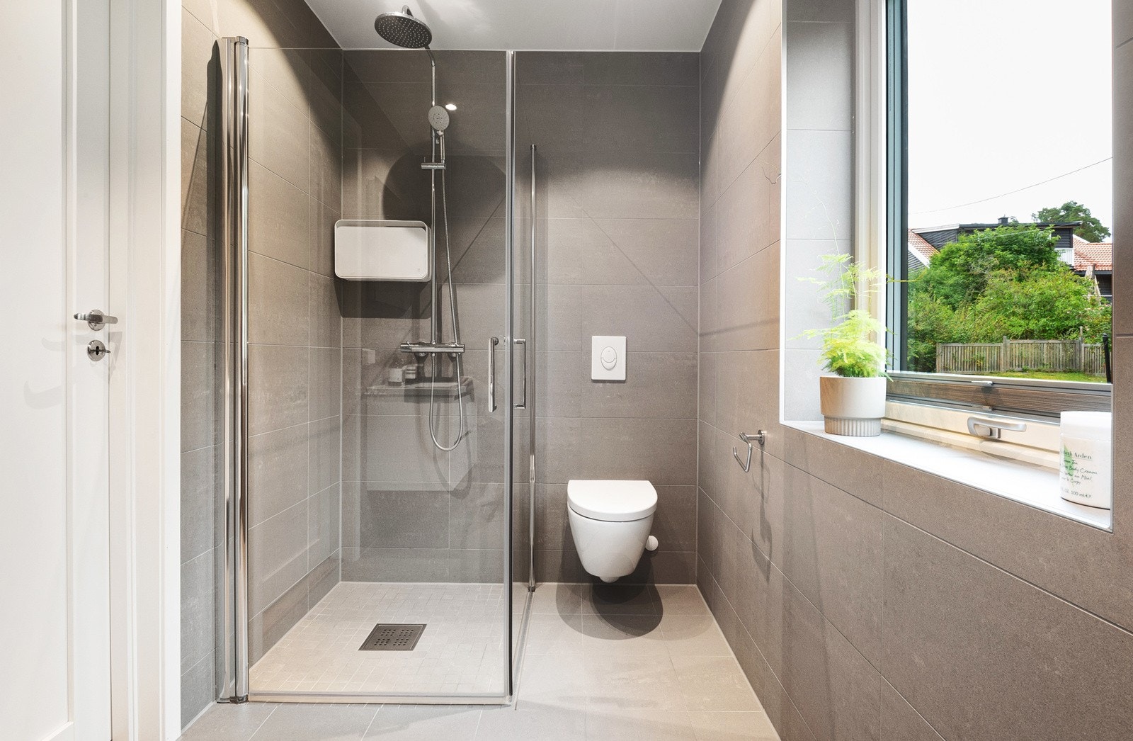 Badet tilknyttet hovedsoverommet har vindu, dusjhjørne med innfellbare glassvegger, hånddusj og regnfallsdusj. Galleribilde