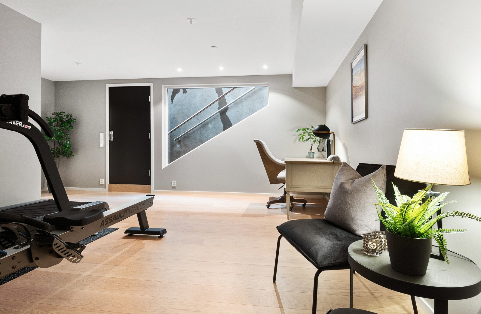 Stuen får dagslys fra et stort vindu på endeveggen ved ytterdøren og har rikelig med downlights i tak. Galleribilde