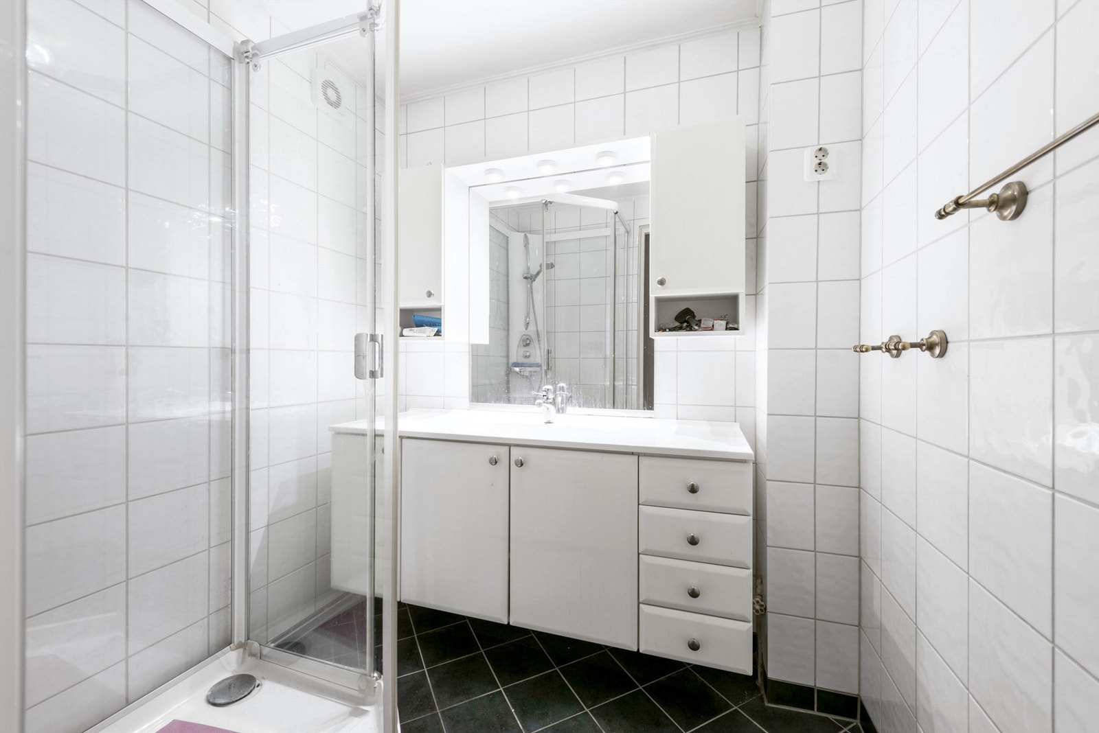 Flislgt bad med dusjkabinett og baderomsinnredning med god skapplass Galleribilde