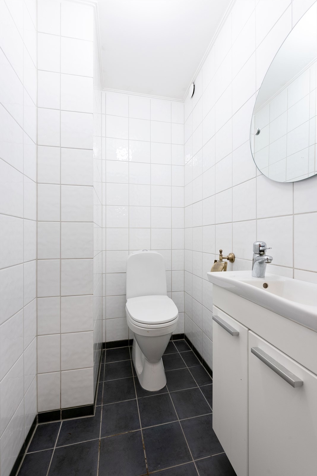 Flislagt toalettrom med servantinnredning Galleribilde