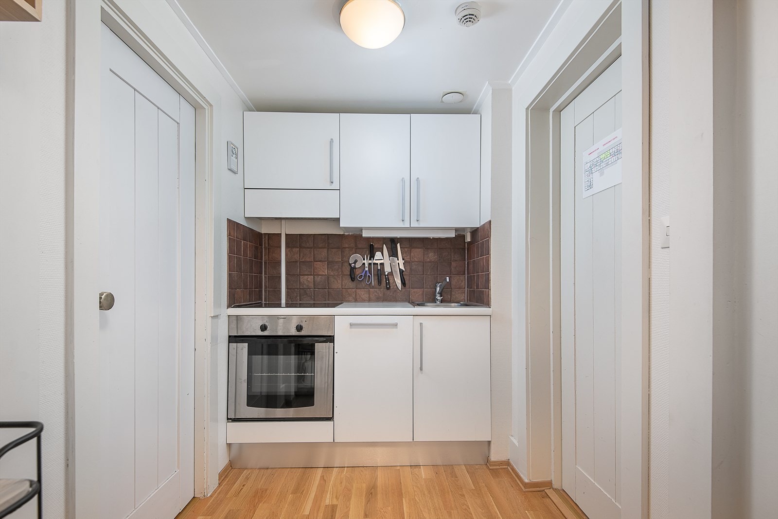 Kjøkkeninnredningen har hvite, slette fronter samt integrert komfyr. Galleribilde