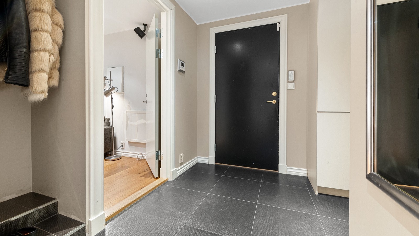 Pent inngangsparti med innebygde løsninger, designerfliser og innebygget nisje for jakker og sko. Det er også inngang til vaskerom med utslagsvask, opplegg for vaskemaskin, innredning/skap, benkeplate samt skapplass. Galleribilde