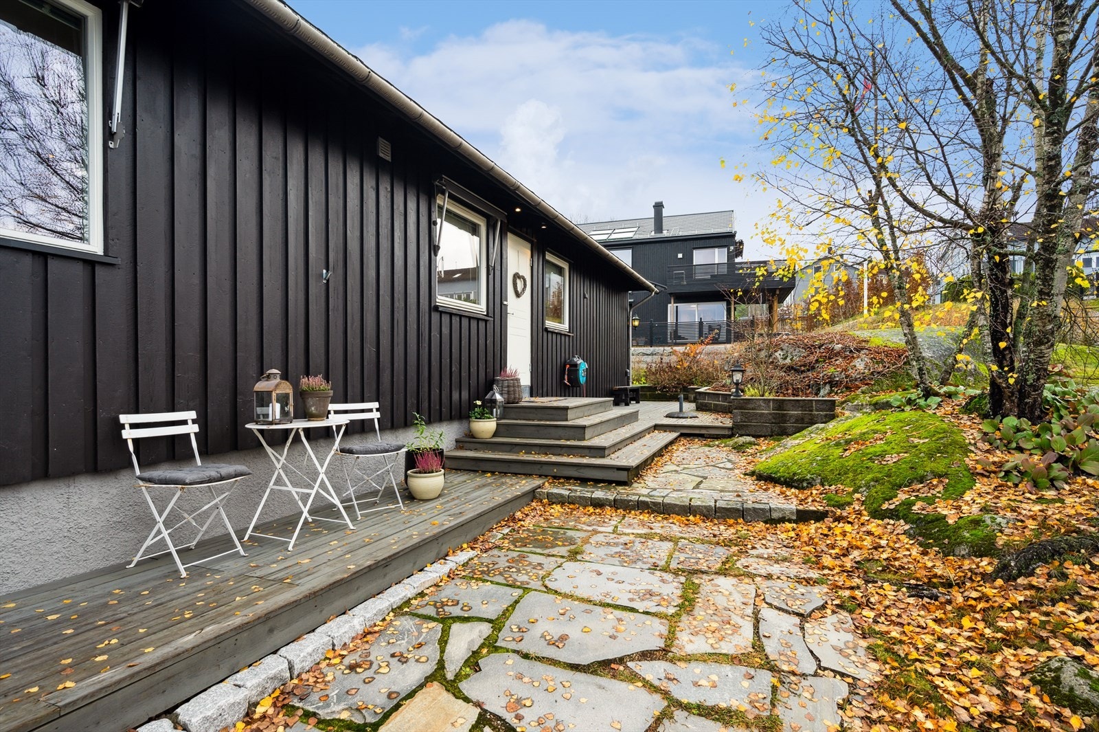 Tomten er pent opparbeidet med blant annet skiferbelagt gangvei til boligens inngangsparti. Galleribilde