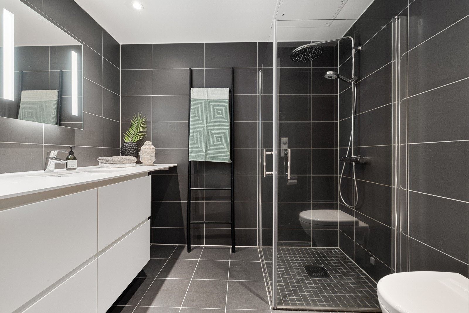 Lekkert baderom med mørke fliser. Galleribilde