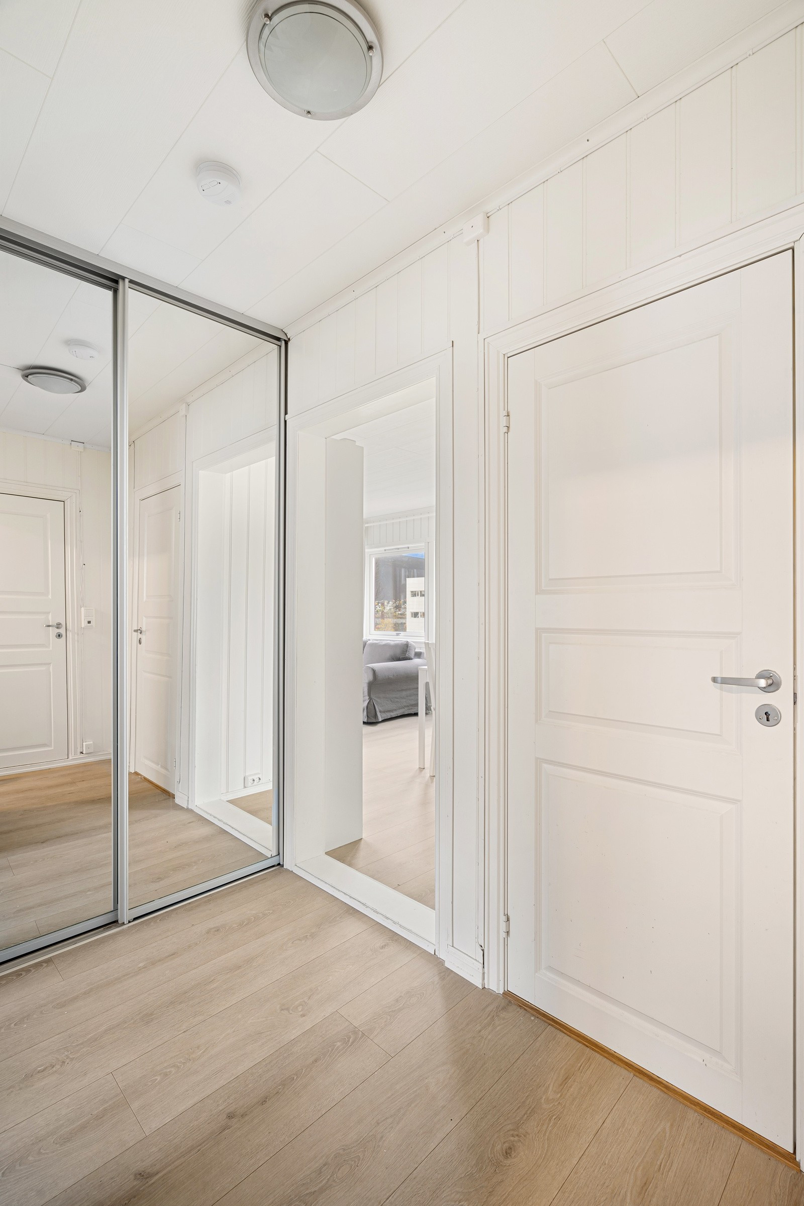 Skyvedørsgarderobe med god oppbevaringsplass i gang.