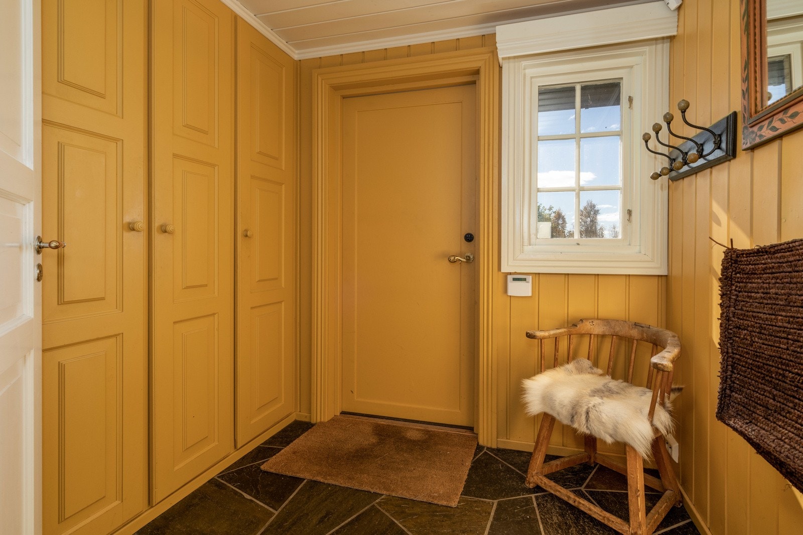 Entréen er innbydende med flott skifer på gulv, malte panelvegger og himling, samt flere garderobeskap. Galleribilde