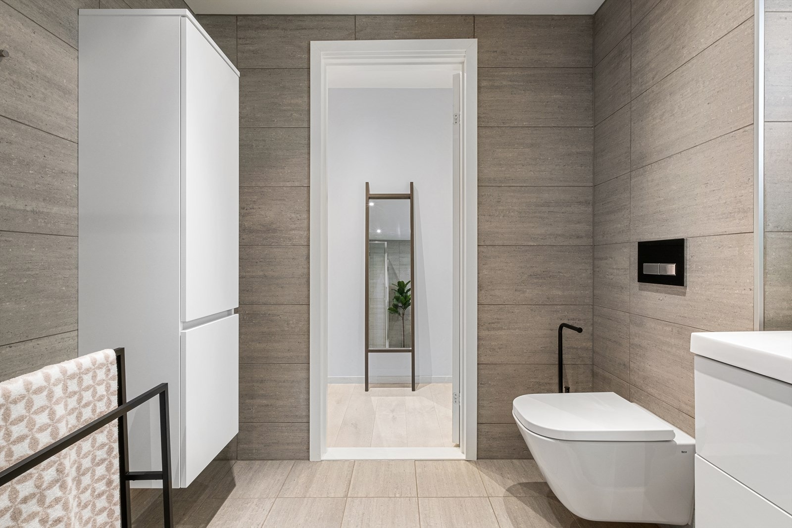 Det er varmekabler i gulvet, vegghengt toalett, håndkletørker og opplegg for vaskemaskin. Galleribilde