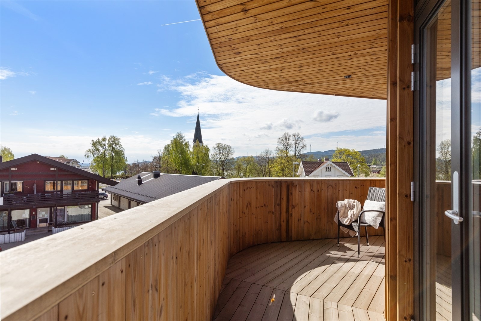 Fra balkongen kan man skue utover hva som skjer i Sand sentrum. Galleribilde