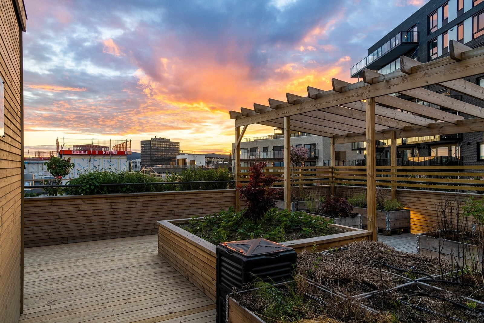Borettslagets takterrasse er innredet med sittegrupper og beplantning Galleribilde