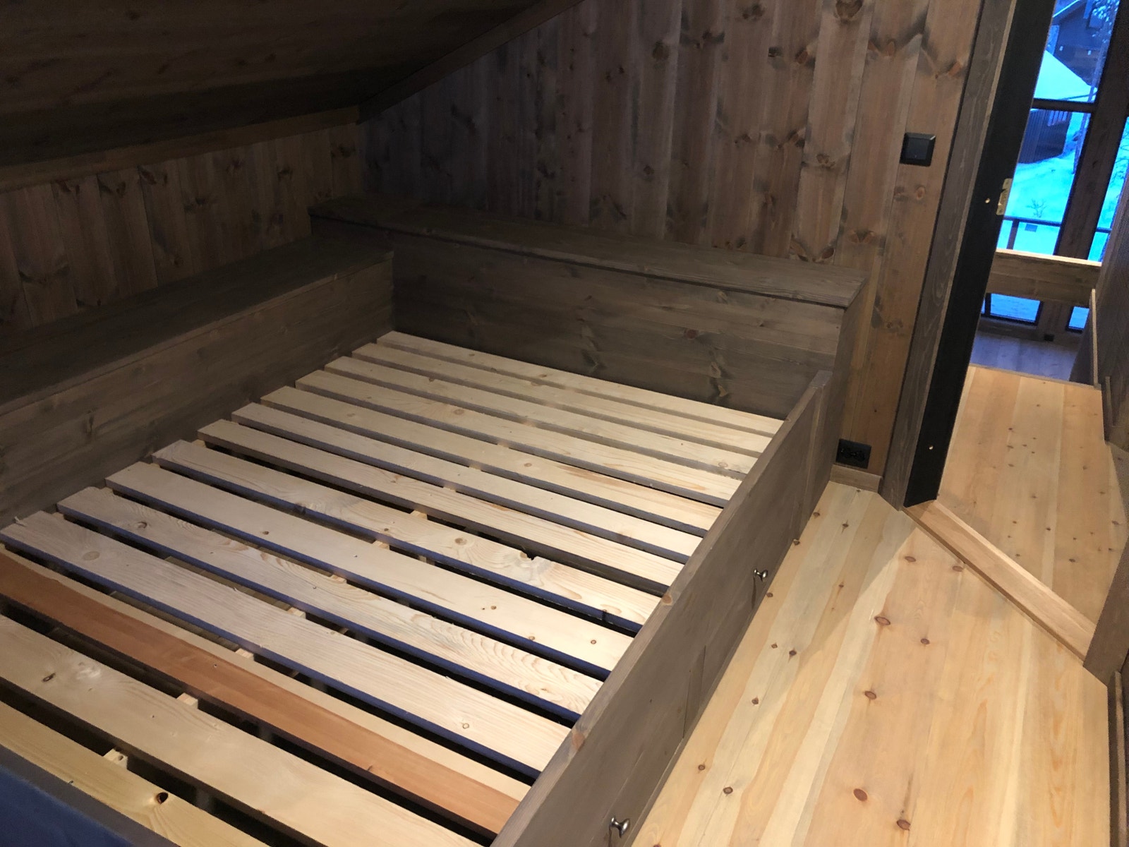 Soverom hems med seng150x200. Kasser med lokk både i hodeenden og langs veggen for oppbevaring av sengetøy, samt 2 skuffer under senga. Beiset i Varde Galleribilde