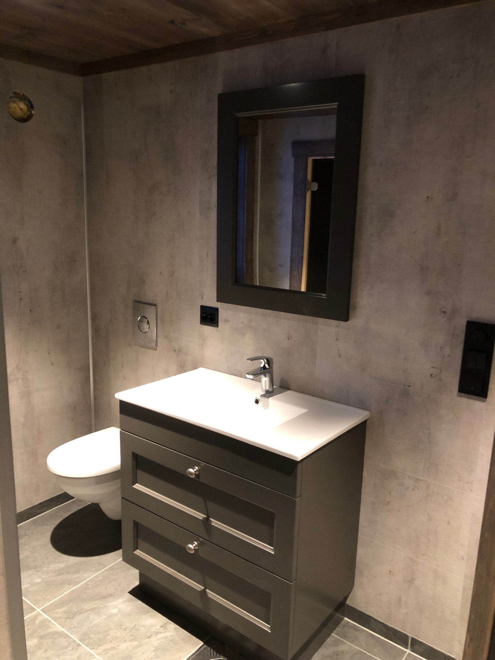 Bad nede med heldekkende vask og vegghengt toalett.
Veggene med kledd med Fibo baderomsplater Galleribilde