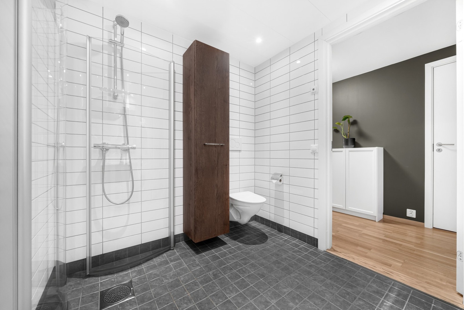 Ekstra lagringsplass i høyskap. Moderne dusjnisje og vegghengt WC, samt downlights i tak. Galleribilde