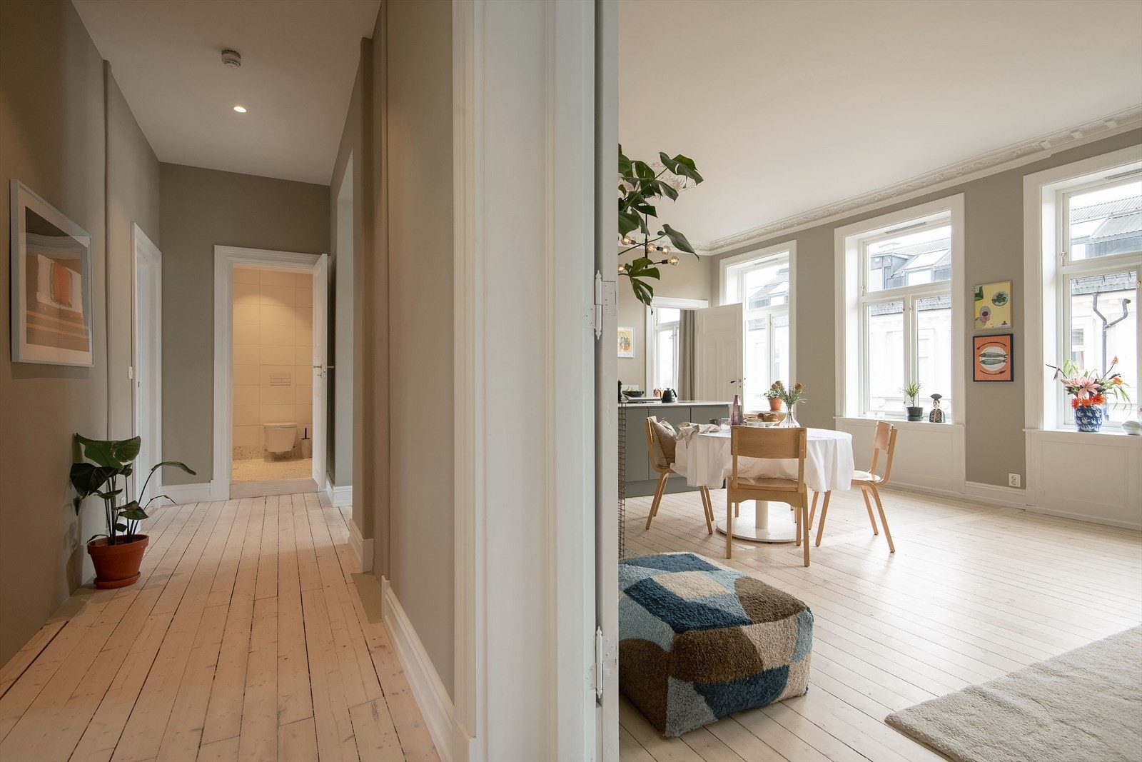 Langstrakt gang som forgrenet seg til leilighetens øvrige rom. Lys fra begge sider av boligen. Galleribilde