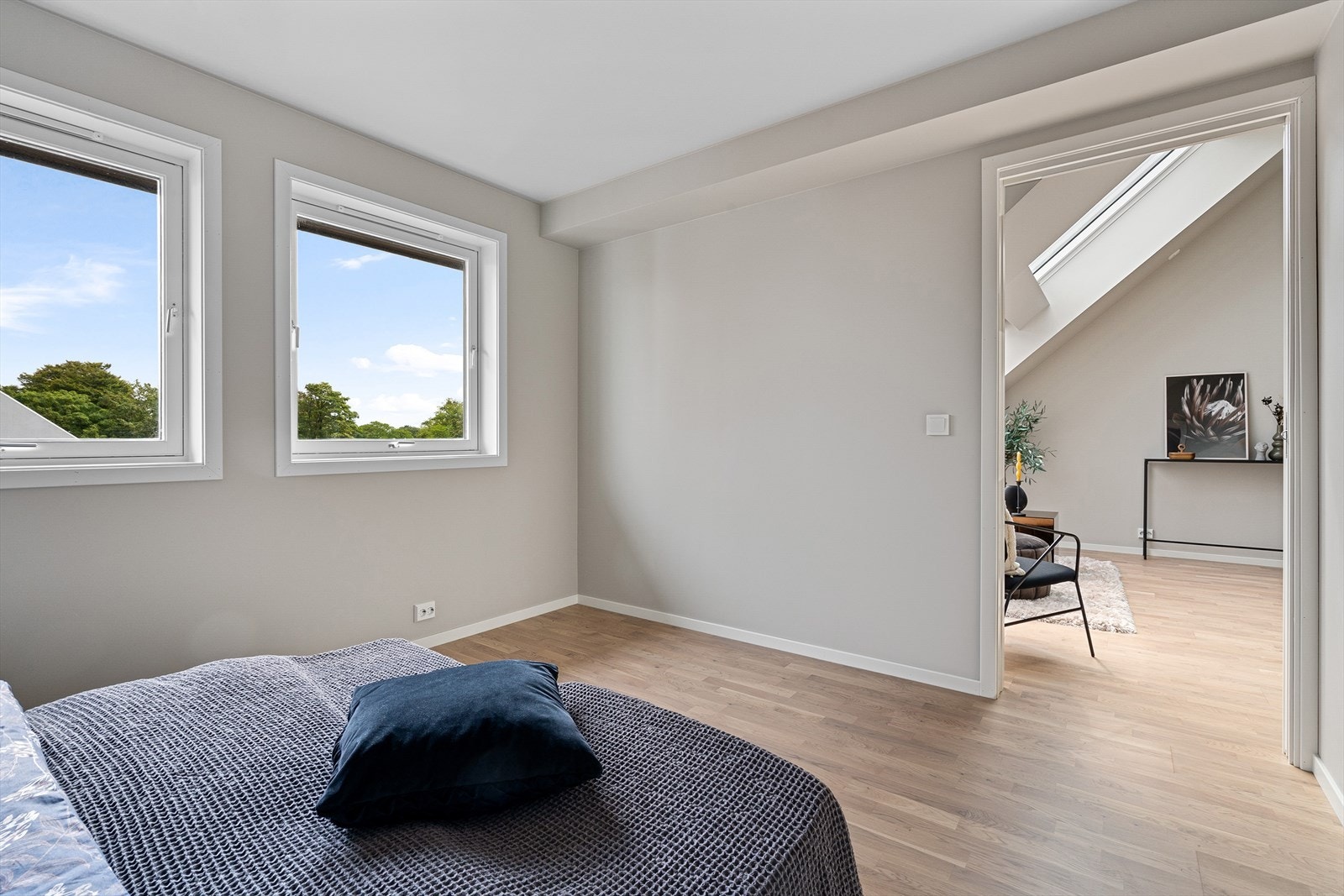 Det er malt i delikate farger og det er skyvedør mellom soverom og stue hvor det er listefritt Galleribilde