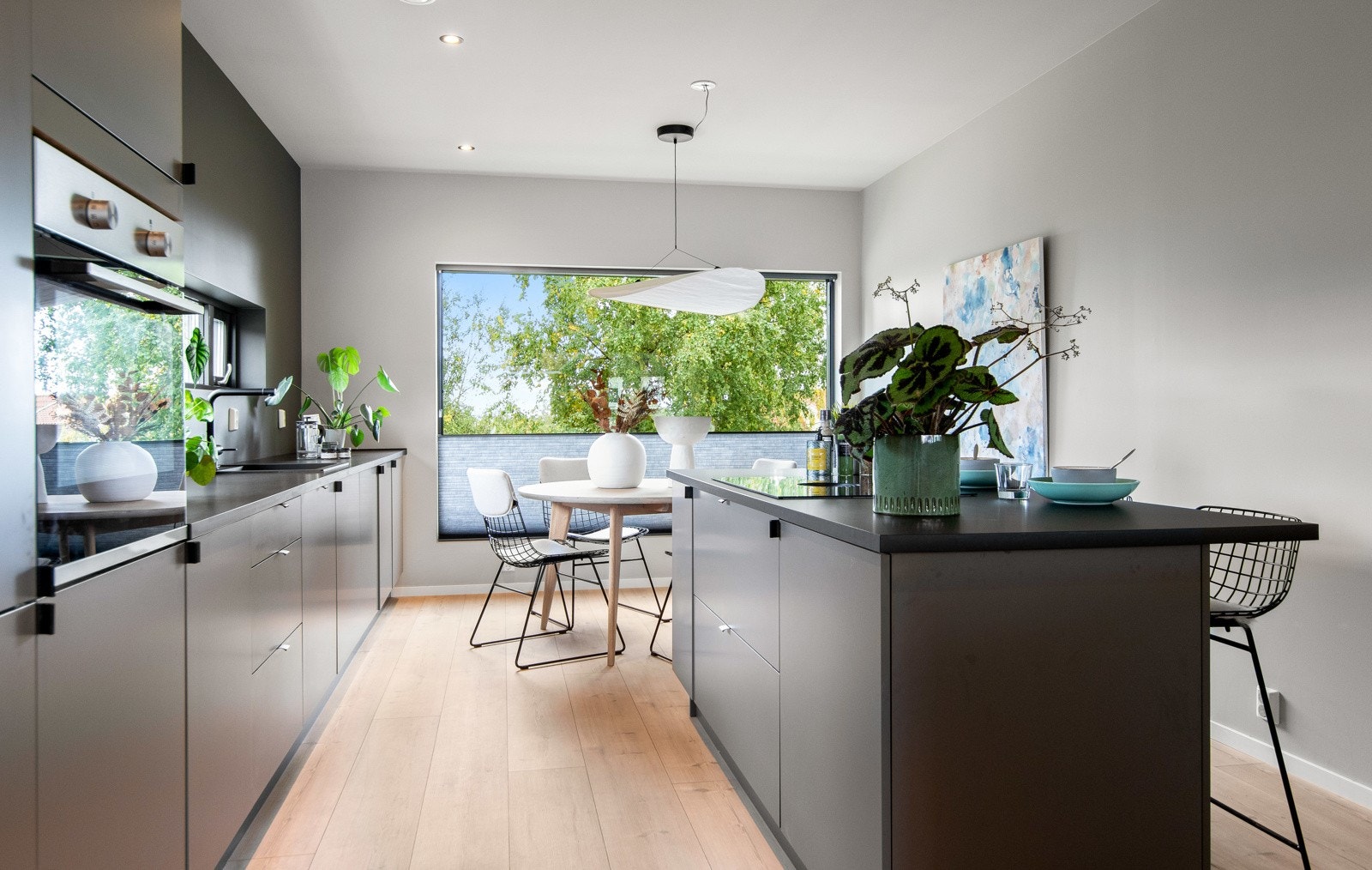 Boligen har et påkostet kjøkken med stilren eleganse og flotte vindusløsninger som byr på grønt utsyn. Galleribilde