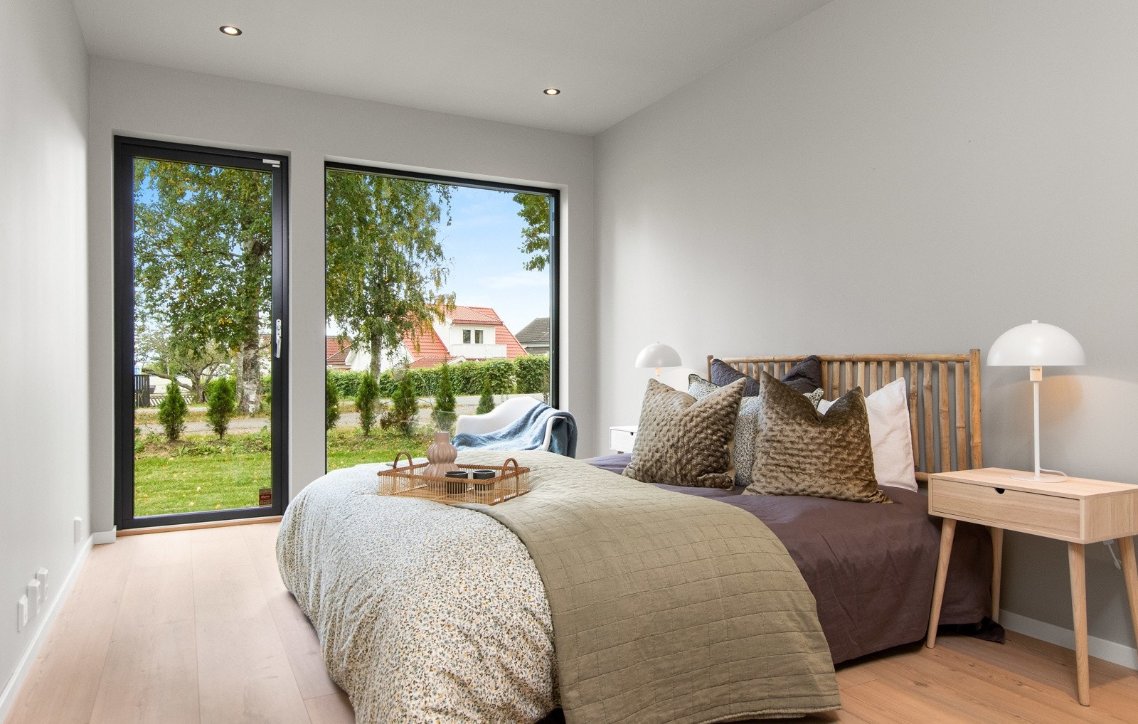 Ett av soverommene i første etasje har stort gulvvindu og dør ut til hagen. Galleribilde