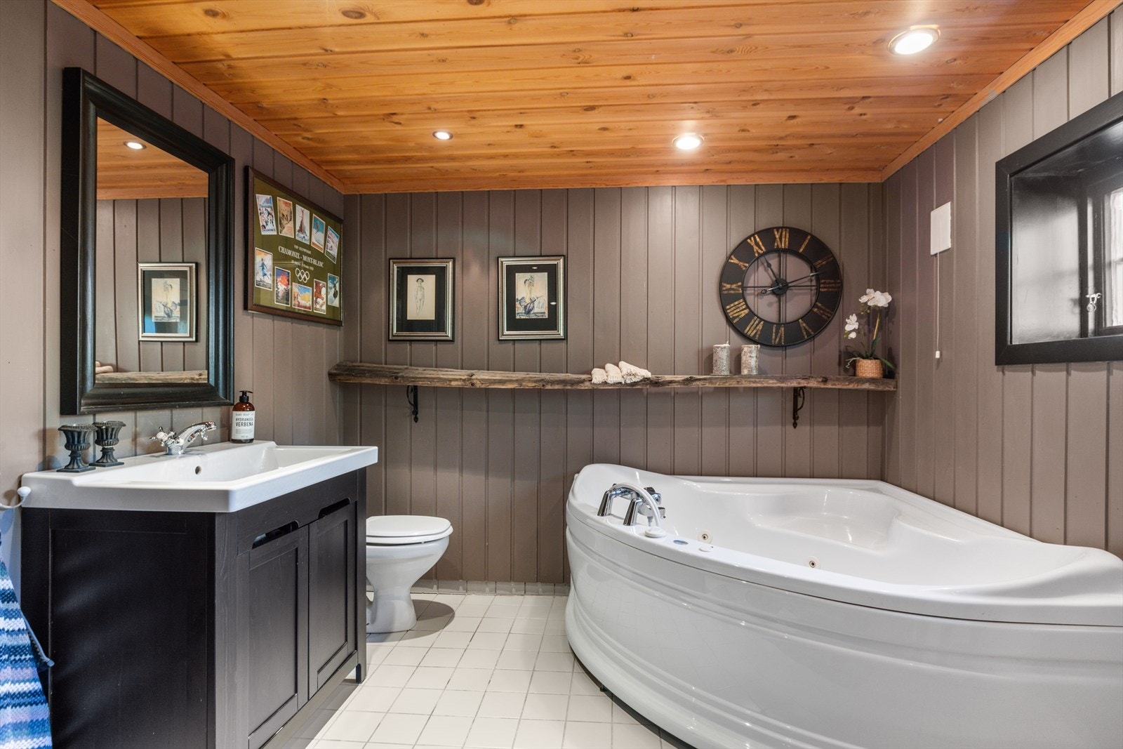 Badet har flislagt gulv med varme, mørk innredning med beiset front, boblebad og tilgang på badstue. Galleribilde