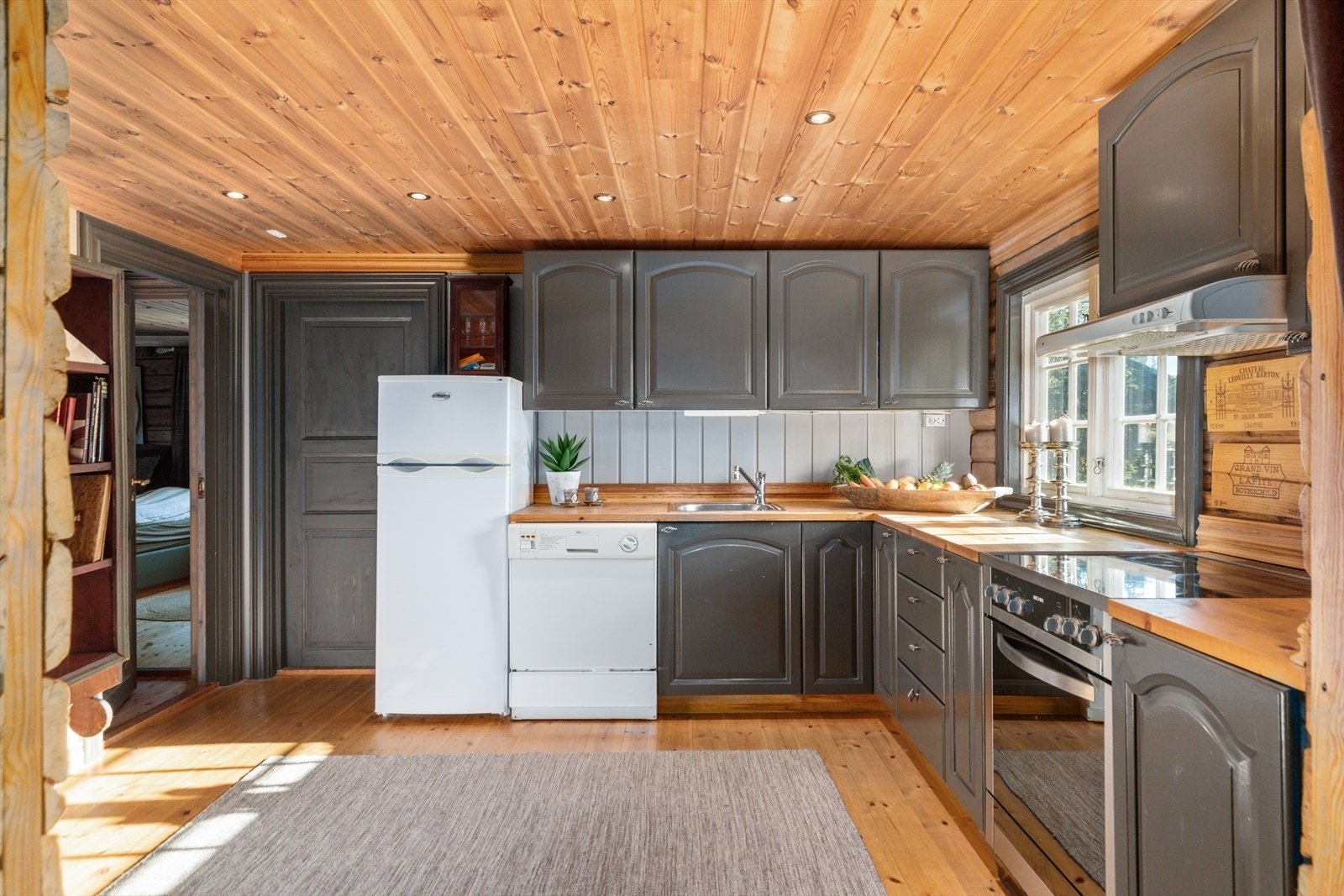 Kjøkken med malte, profilerte fronter og avsatt plass til hvitevarer - Kjøkkenet ligger i eget rom og har godt med skap- og benkplass. Galleribilde