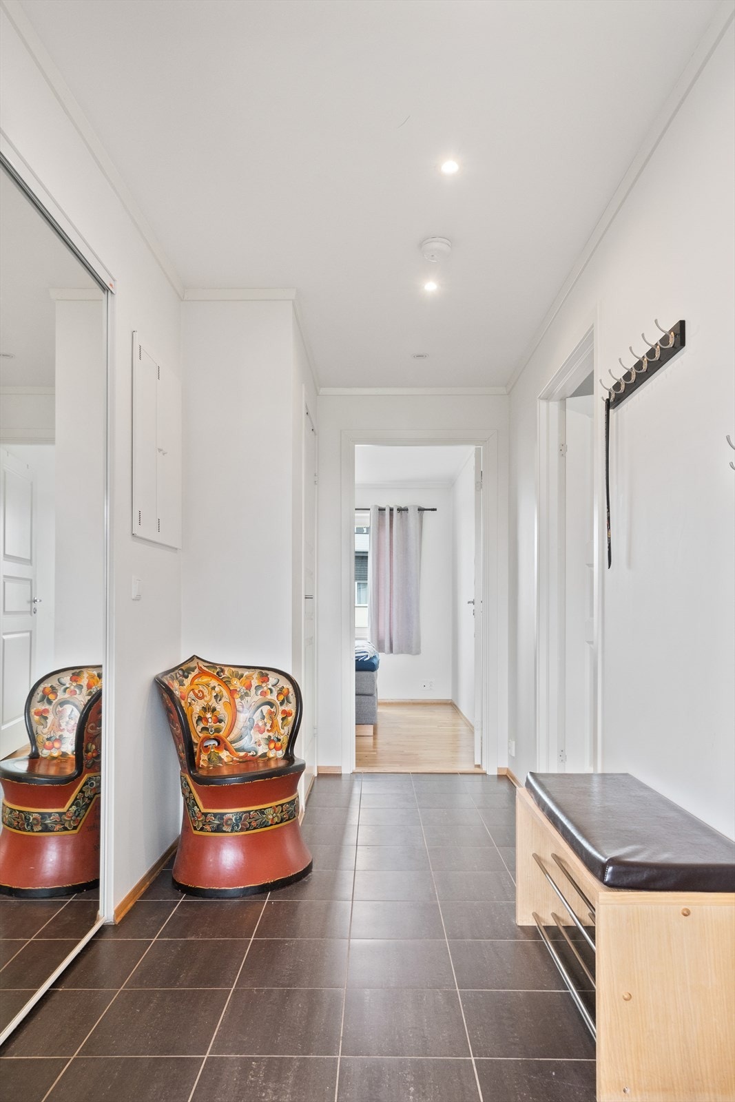 Innenfor døren blir du møtt av en lys entré som gir et godt førsteinntrykk. Entréen er praktisk innredet med skyvedører i speil med gode oppbevaringsmuligheter. Galleribilde