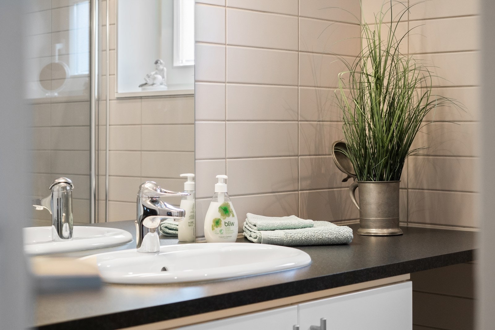 Begge bad er flislagt i lyse toner, har gulvvarme og belysning. Galleribilde