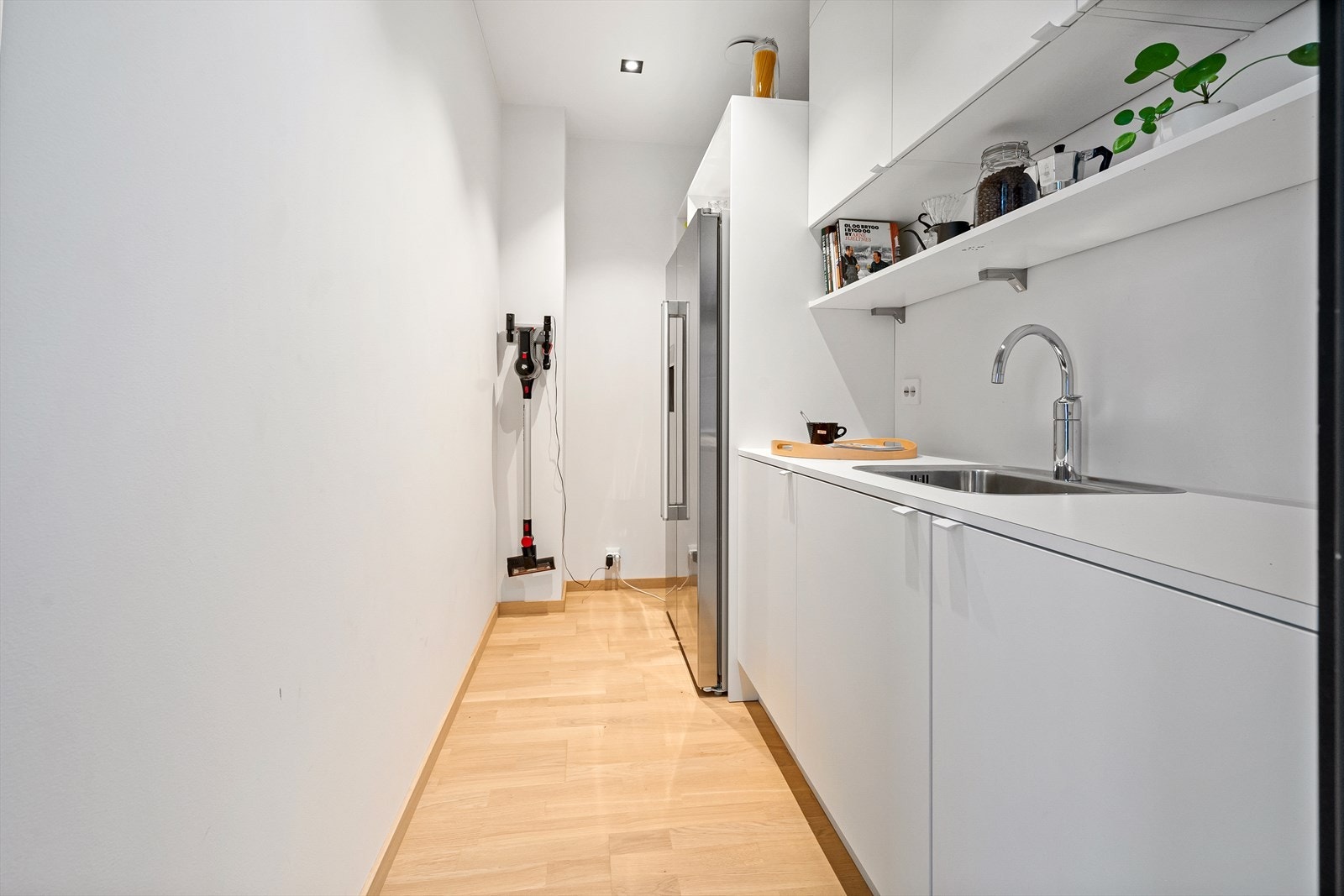 Bak kjøkken er det et praktisk grovkjøkken med full innredning og side-by side kjøleskap Galleribilde