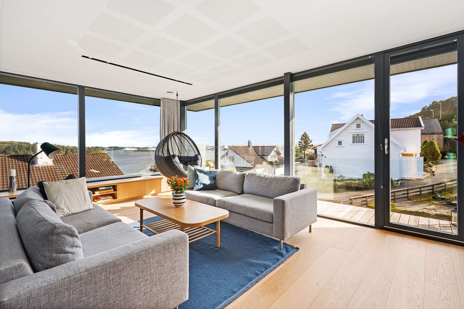 Lys og lekker stue med store glassflater Galleribilde