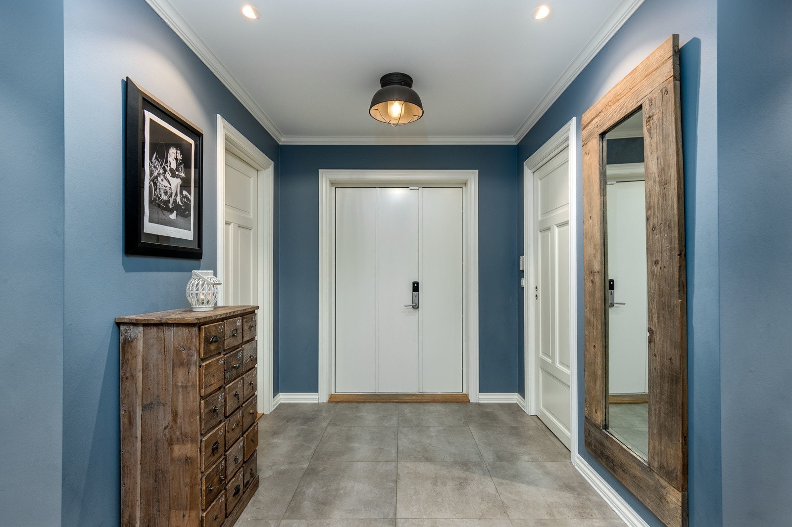 Lys og innbydende entre med delikate storformatfliser på gulv med vannbåren gulvvarme, som gir et godt førsteinntrykk av boligen. Det er montert Yale doorman kodelås på ytterdør - meget praktisk for en familie. Galleribilde