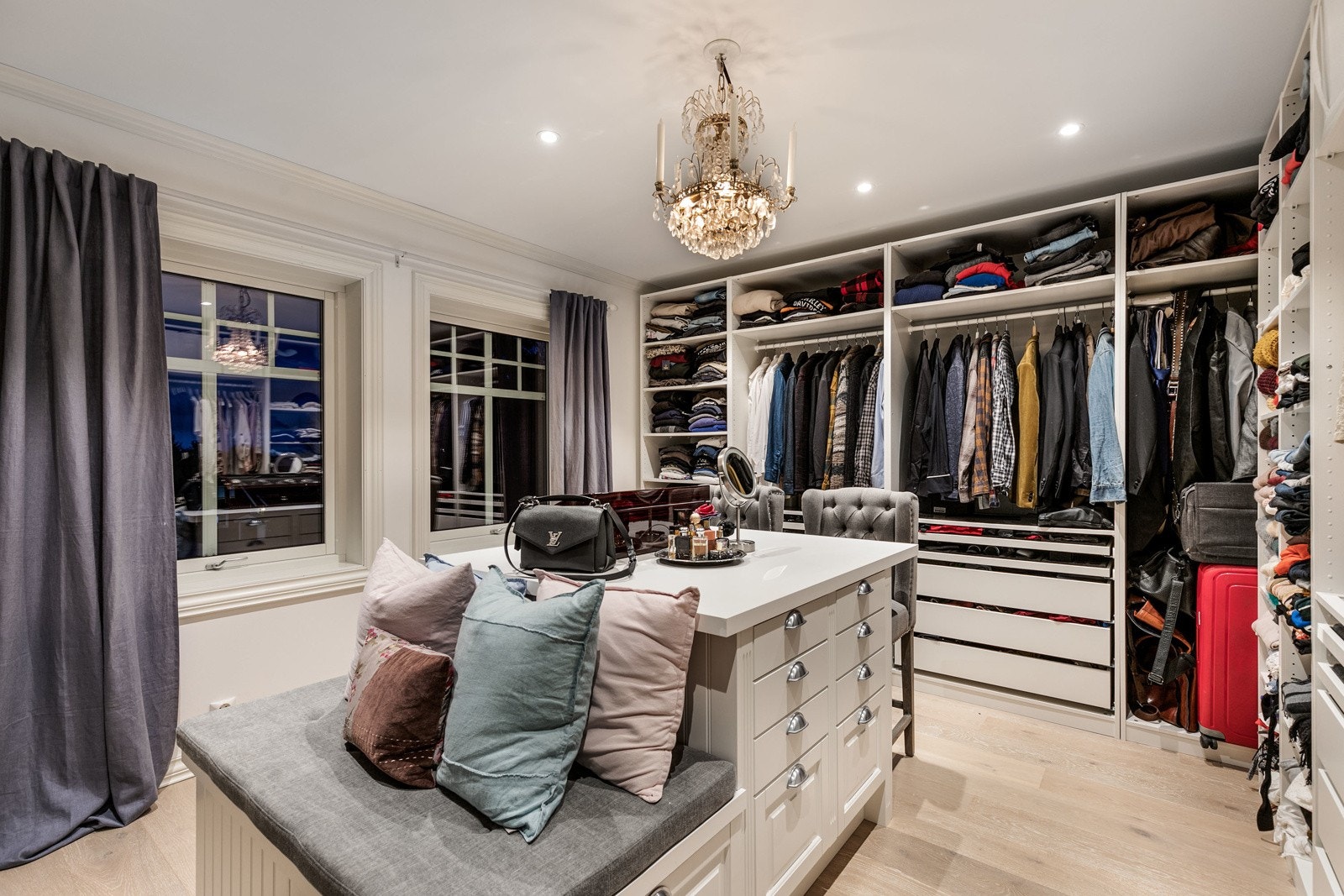 Direkte adkomst fra hovedsoverommet til praktisk omkledningsrom på ca. 17,9 kvm BRA - inneholder bla. takhøy skapinnredning med hyller, oppheng og diverse skuffer, samt en stor øy midt i rommet m/div. mindre skuffer og sitteplass Galleribilde