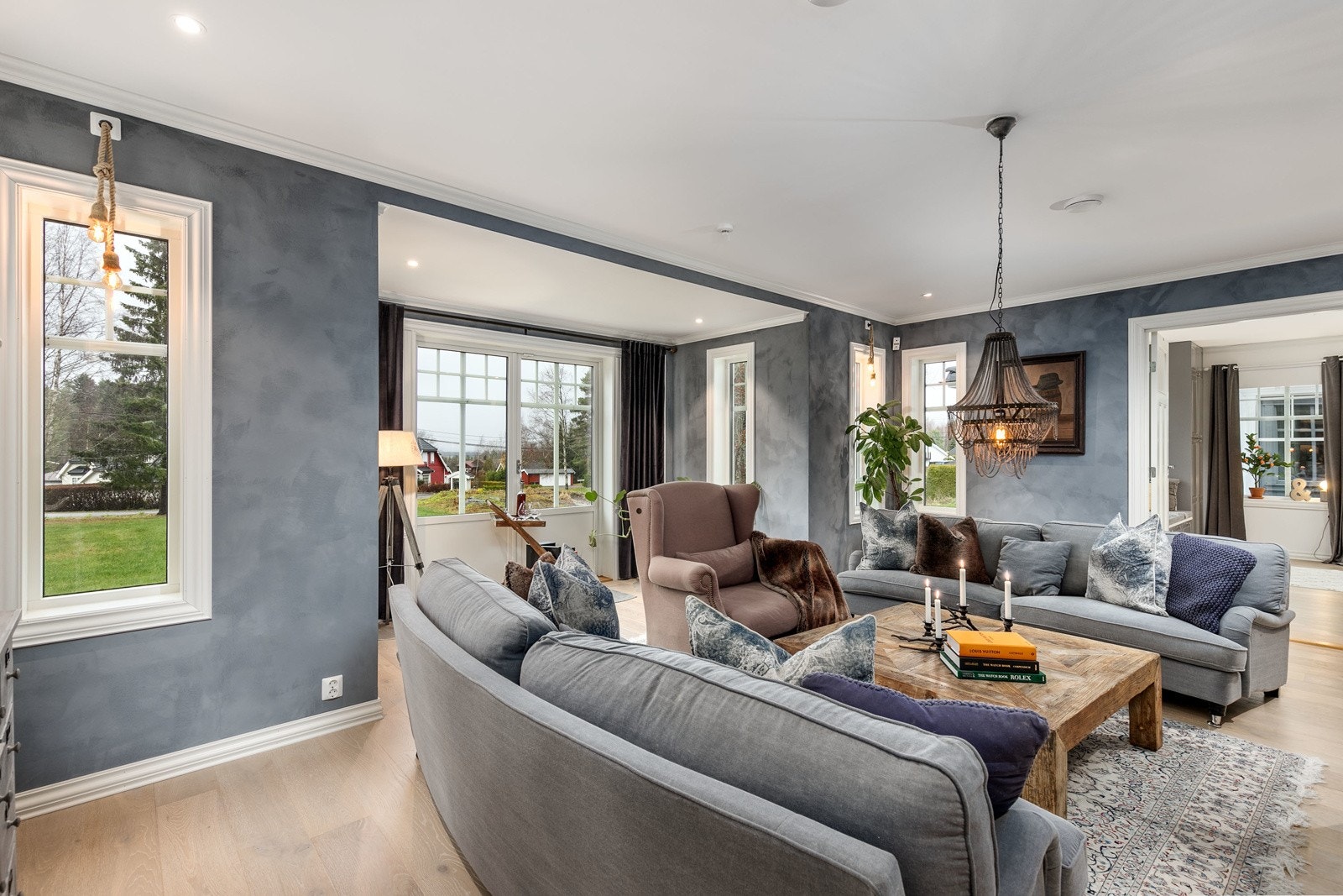 Fra spisestuen føres man via en profilert tofløyet dør inn i den innbydende peisestuen. De store vindusflatene i flere himmelretninger slipper inn rikelig med lys og gir en meget luftig romfølelse. Galleribilde