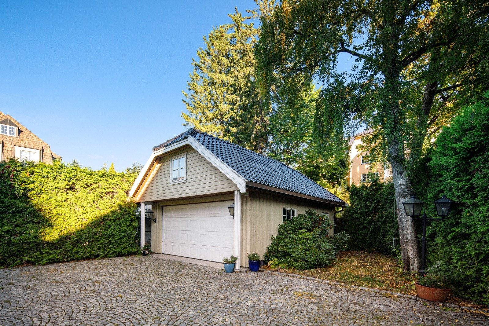 Det er parkering i en frittliggende dobbelgarasje på ca. 33 kvm fra 2007 og på en stor, steinbelagt gårdsplass. Galleribilde