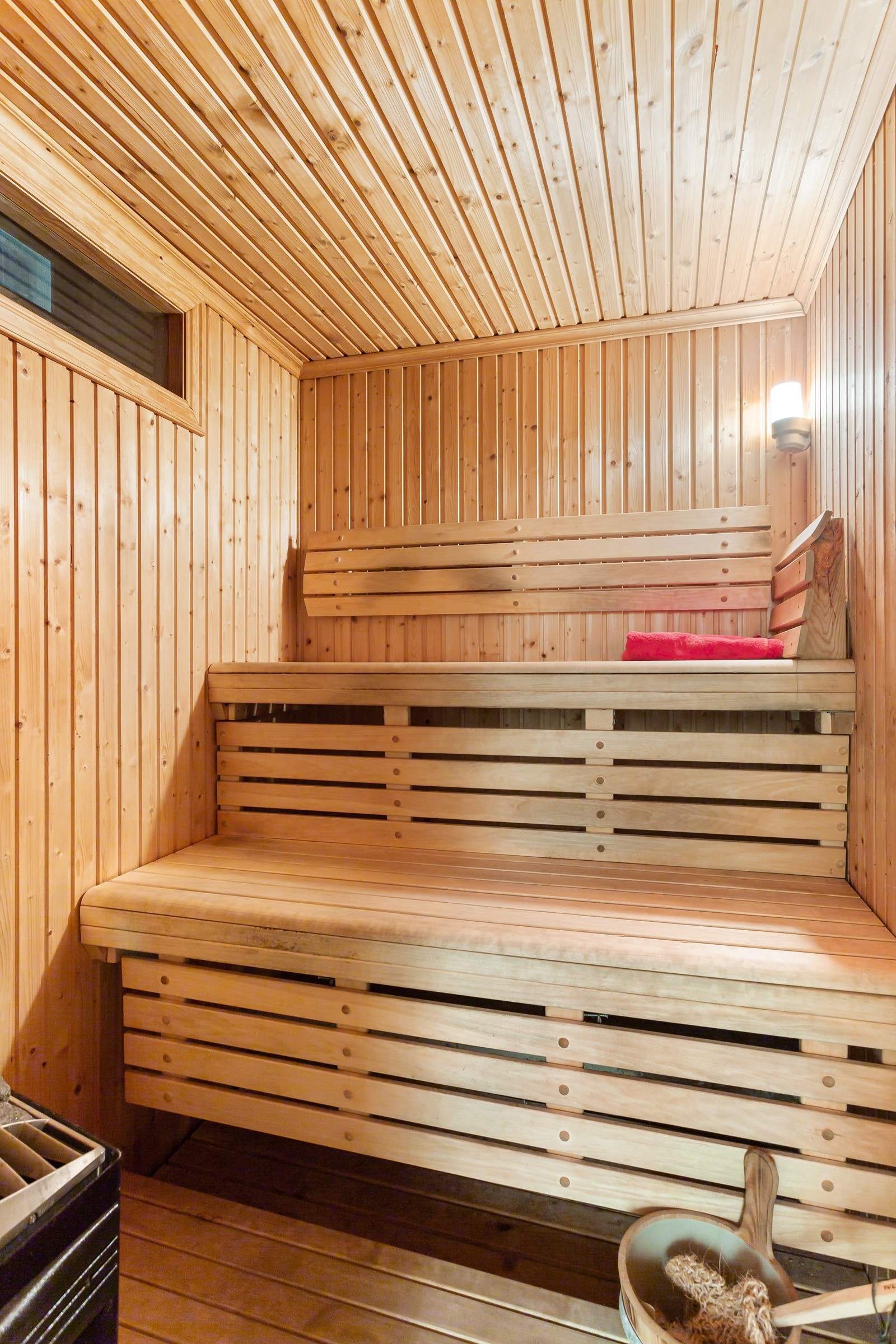 Badstuen har elektrisk ovn og plassbygde sittebenker i tre. Galleribilde