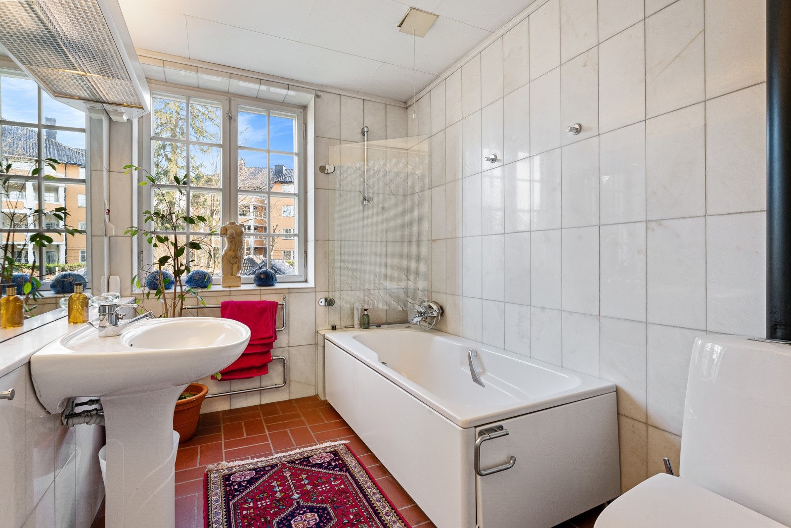 Ved soverommene i andre etasje er det et romslig bad med lyse fliser i marmor på veggene og terrakottafargede fliser på gulv med gulvvarme. Galleribilde