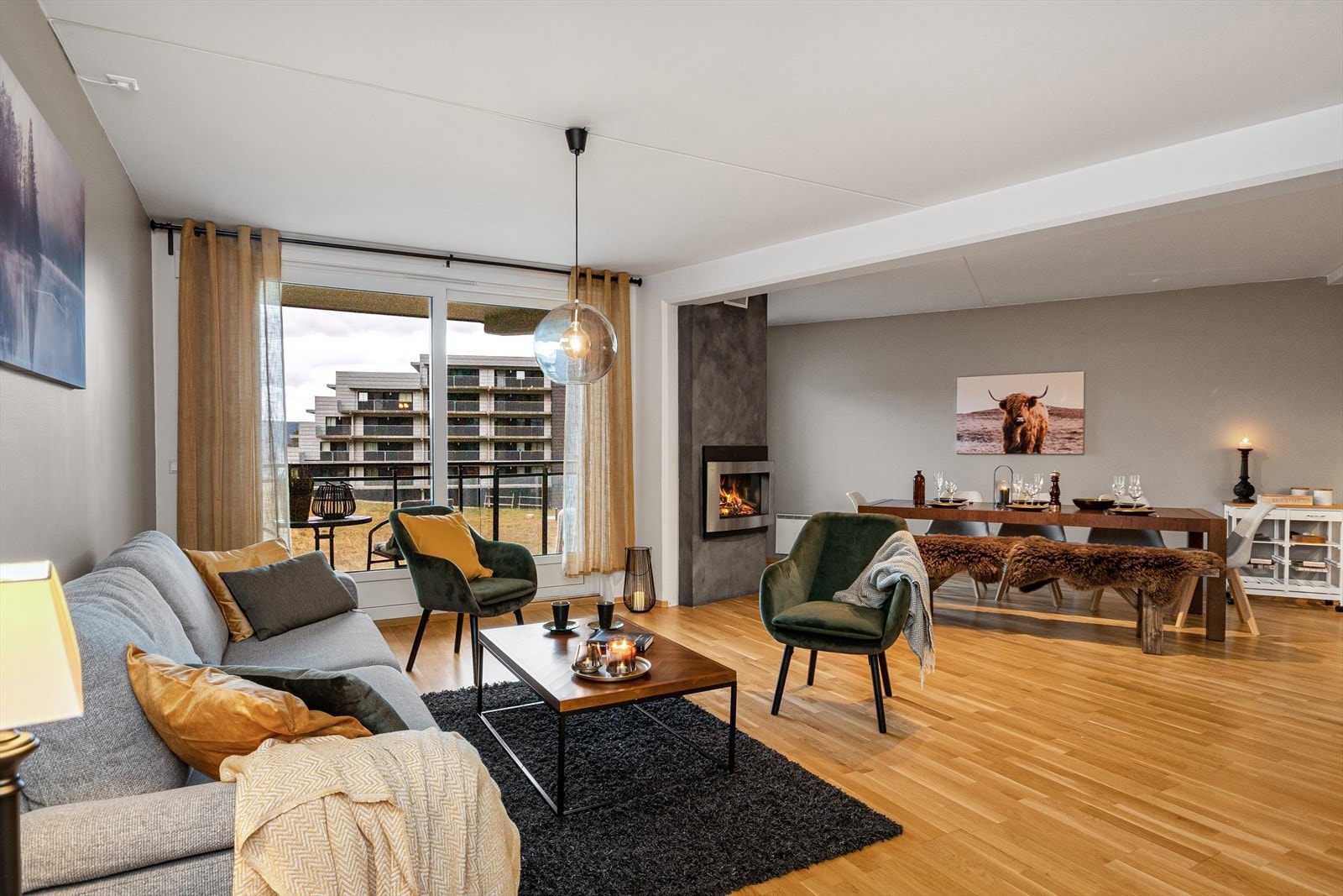 Stuen ligger i en åpen planløsning med spisestue og kjøkken Galleribilde