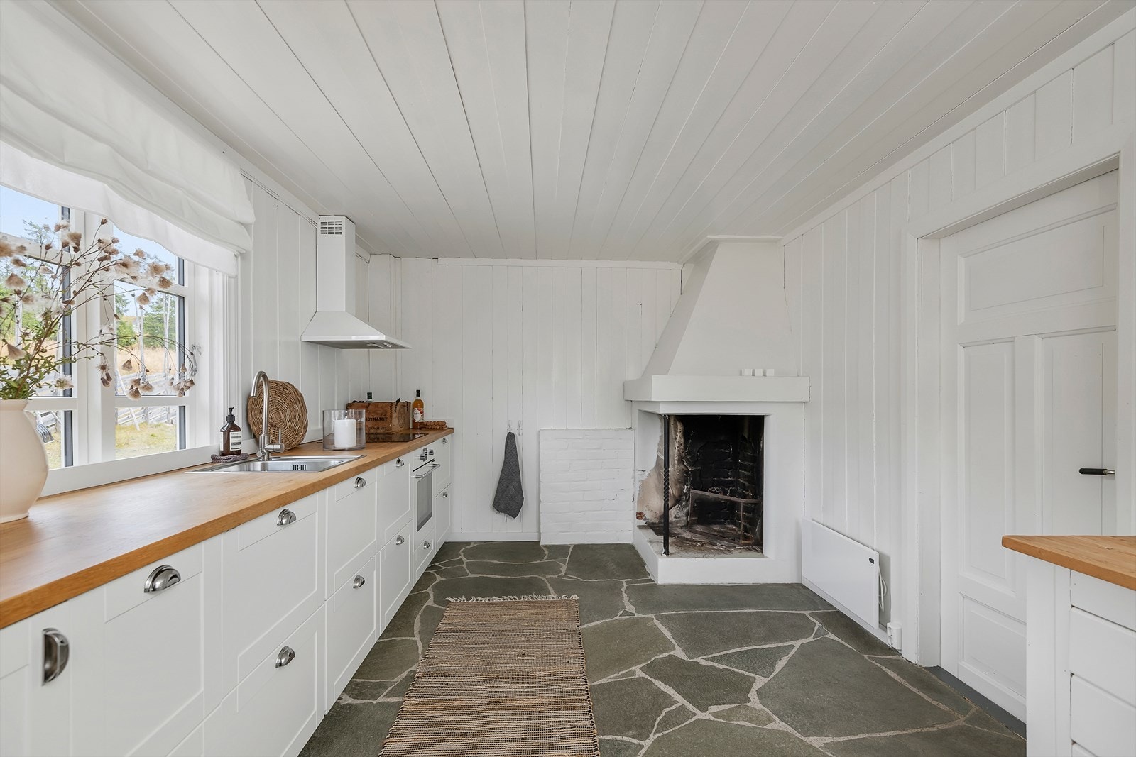 Innredningen har lett profilerte fronter i malt utførelse. Rikelig med skap-og benkeplass. Vindu over benk. Galleribilde