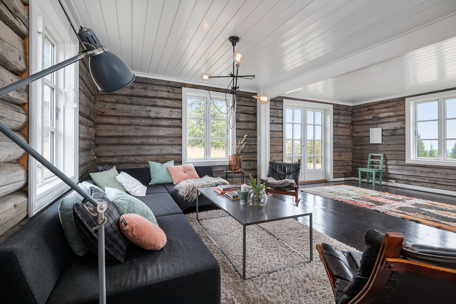 Sjel og sjarm i stua med lune tømmervegger. Selger har en fin miks av gammel stil og moderne touch. Galleribilde