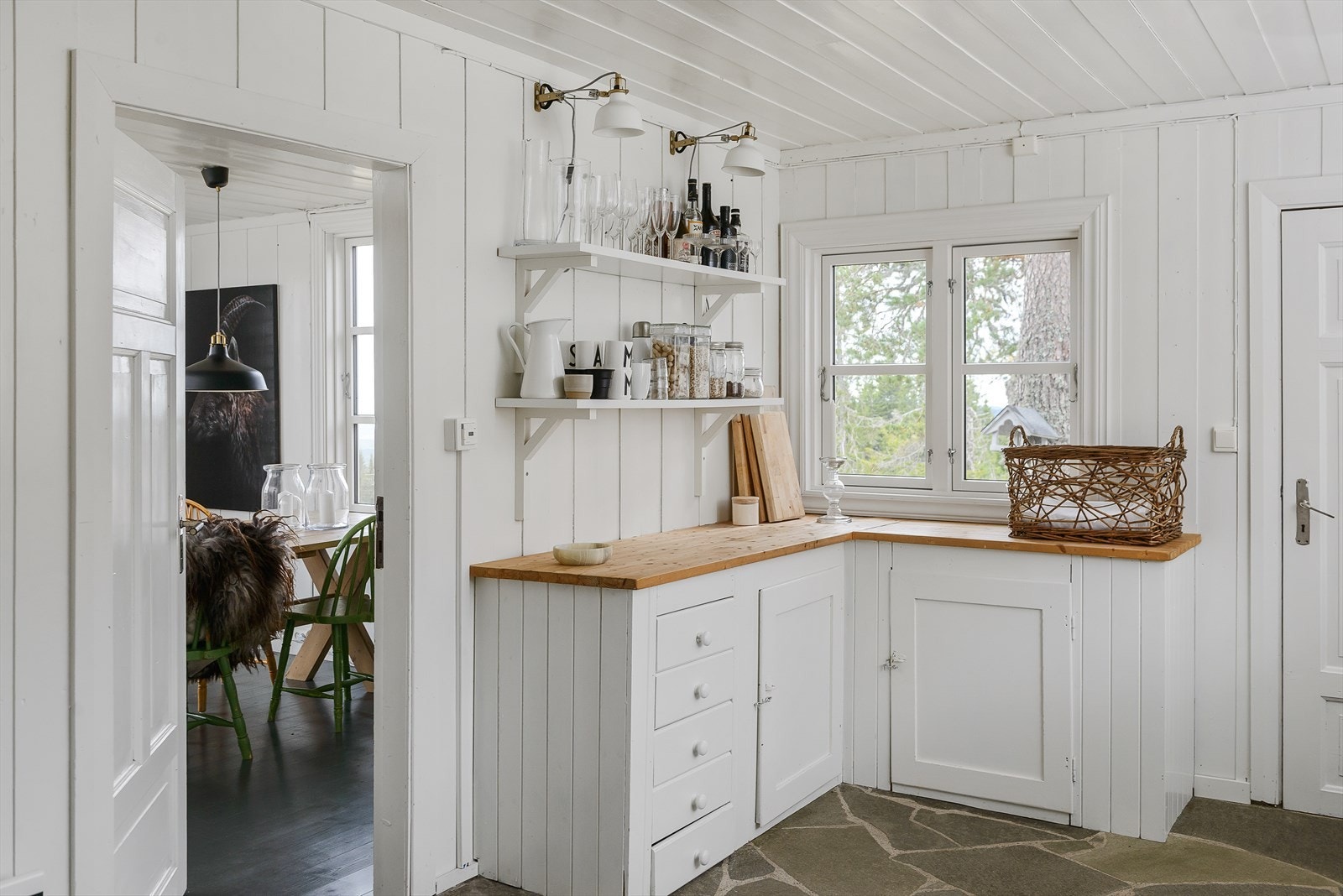 Dør og adkomst fra kjøkkenet og ut til spisestua. Innredning, vegger og tak malt i samme lyse tone, noe som gir et delikat og helhetlig inntrykk. Galleribilde