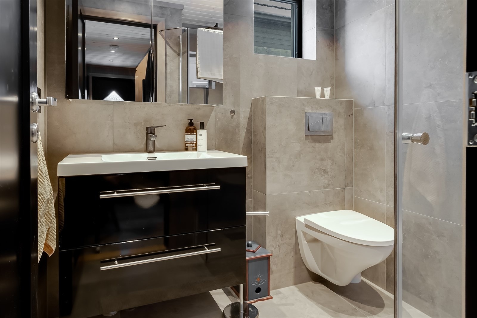 Flislagt bad med baderomsinnredning med skuffer og heldekkende servant, wc og dusjhjørne. Galleribilde