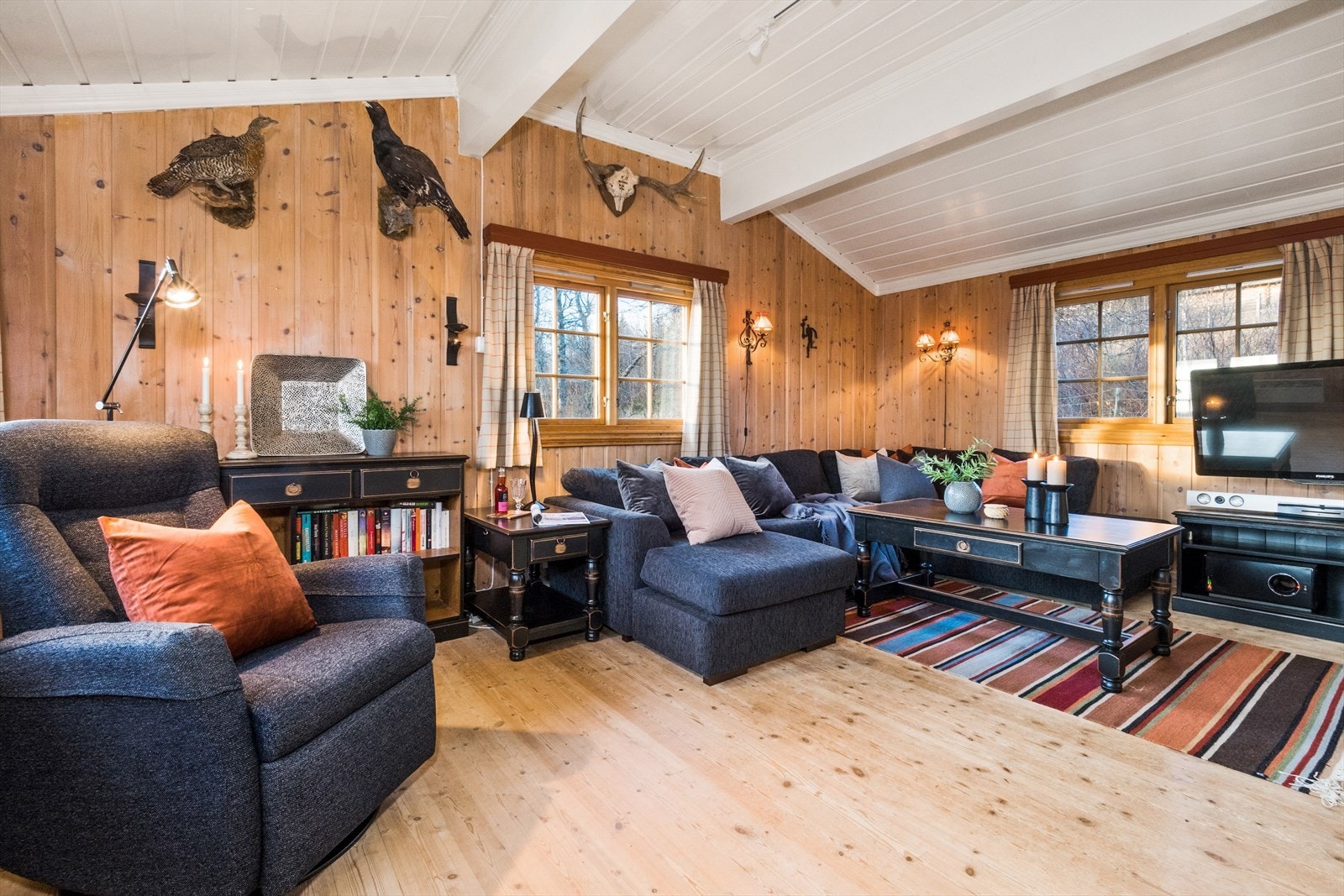 Stuen ligger i delvis åpen løsning mot kjøkkenet, som deles av med peisen i stua. Galleribilde