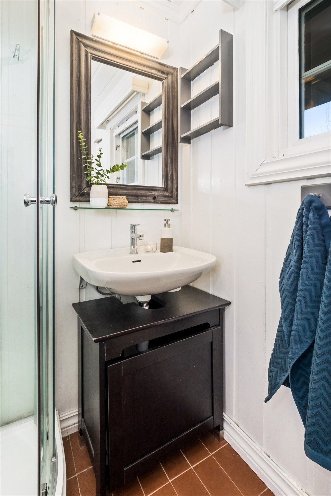 Det er gulvmontert toalett, dusjkabinett og vask med underskap. Galleribilde