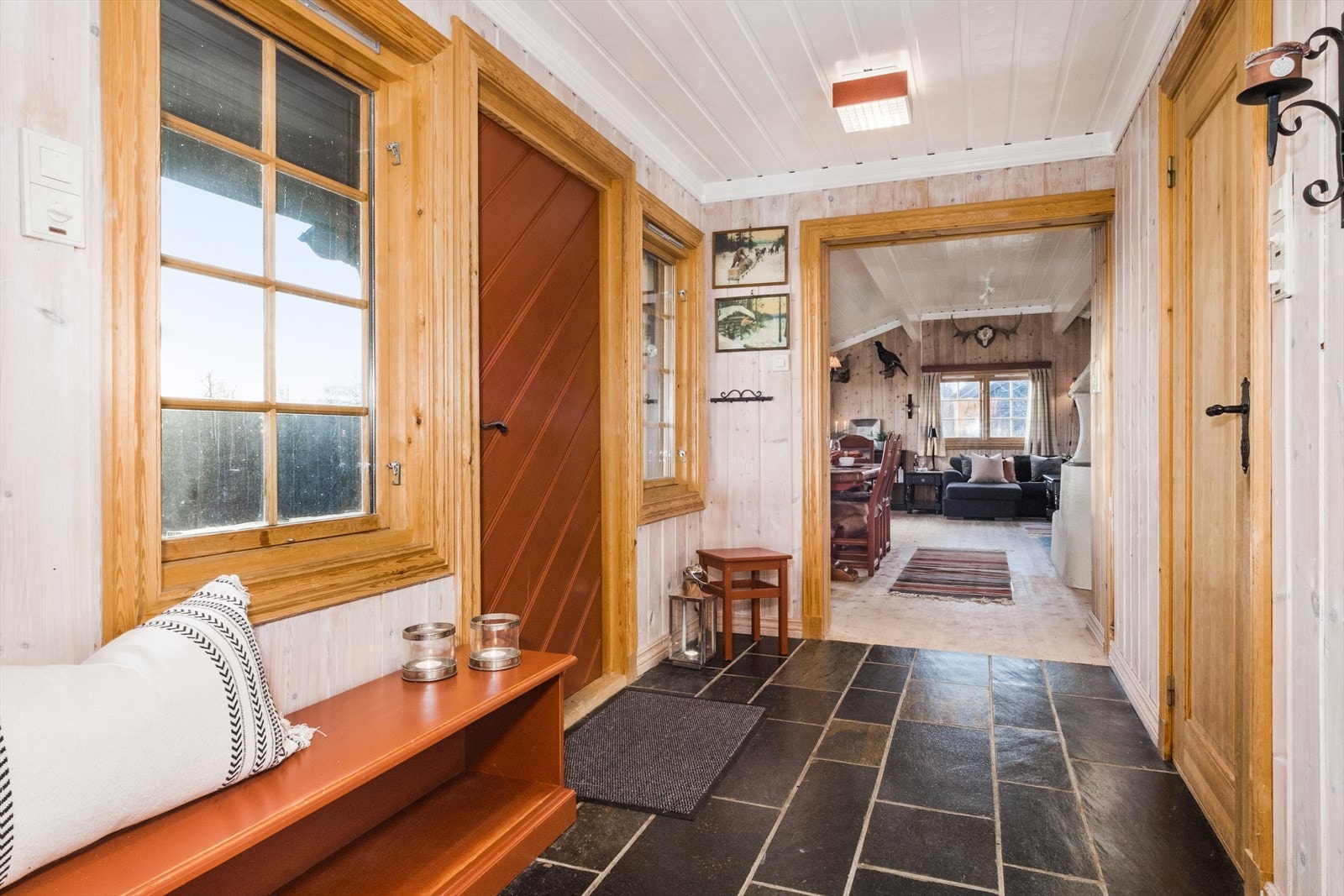 Fra overbygget inngangsparti kommer man inn en romslig og praktisk entré/gang med varmekabler og fliser på gulv. Galleribilde