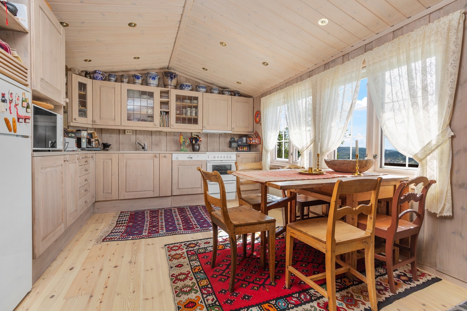 Pent kjøkken med koselig spiseplass ved vinduet Galleribilde